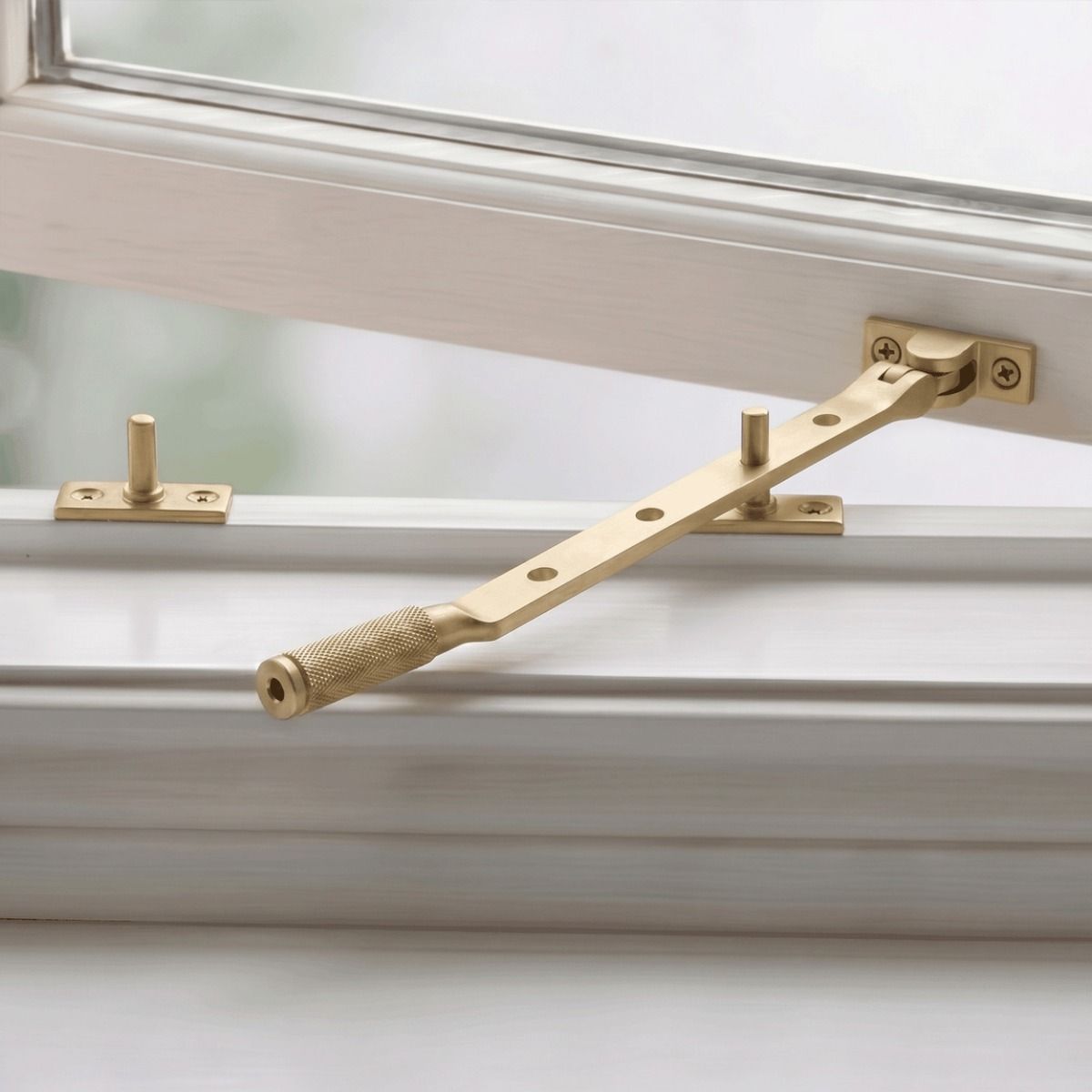 The 10" Satin Brass "Royale" Four Pin Window Stay Fitted on a Traditional White Painted Window - Digital Illustration 