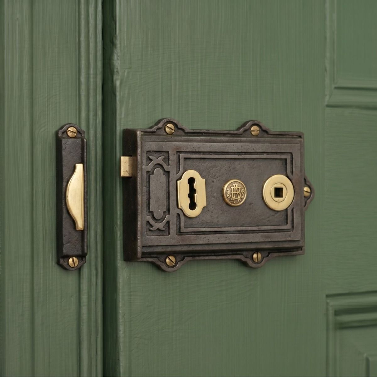 The 12.5cm Cast Iron & Polished Brass Ornate Rim Lock Mounted on a Green Wooden Door - Digital Illustration