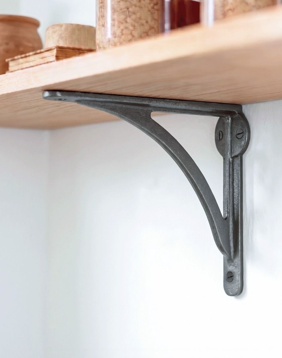 The 14 x 18cm Natural Iron Curved Shelf Bracket Mounted on a White Kitchen Wall in a Contemporary Home - Digital Illustration 