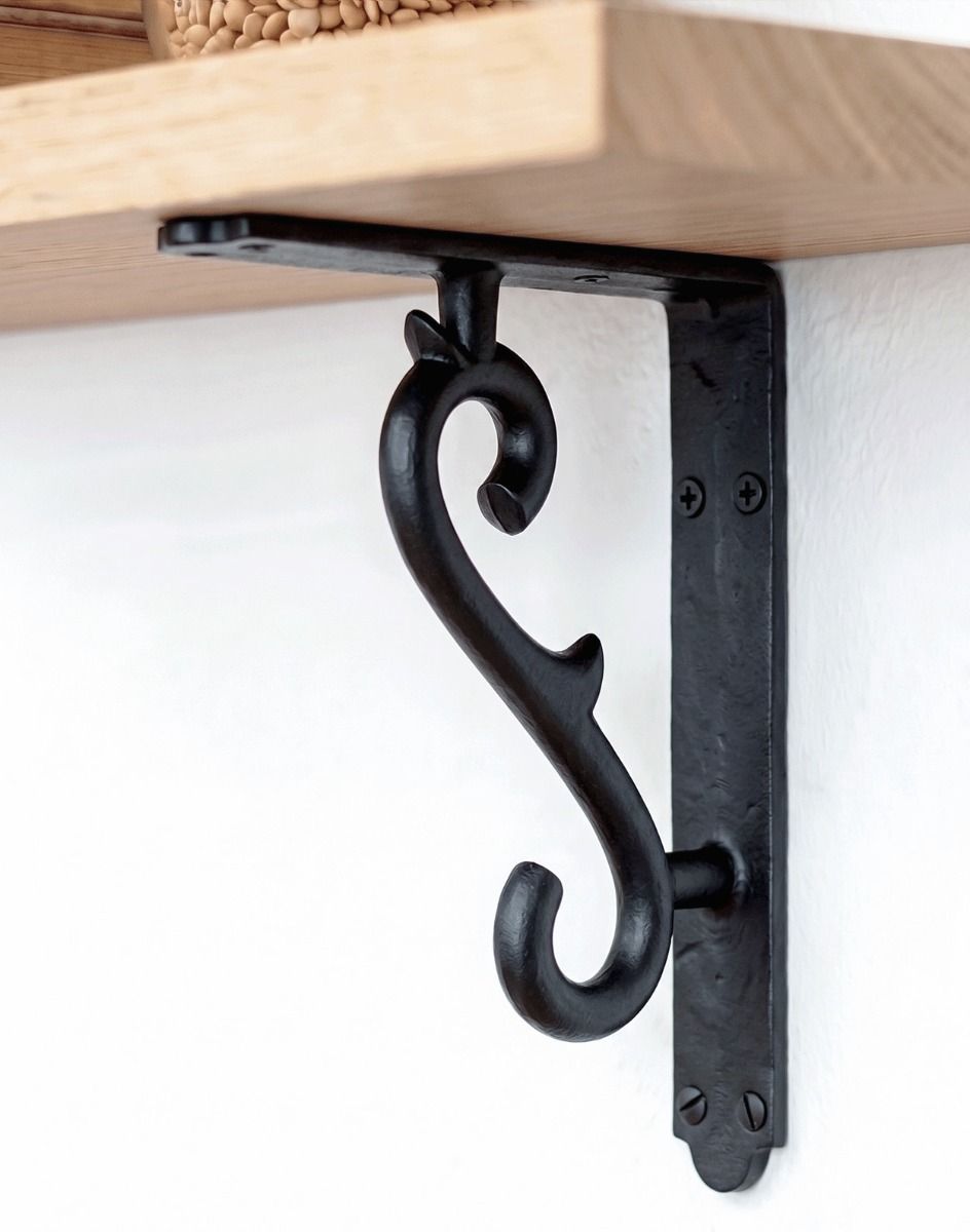 The 18 x 14cm Scroll Effect Wall Bracket in Cast Iron Mounted on a White Wall as Part of a Wooden DIY Shelf - Digital Illustration 