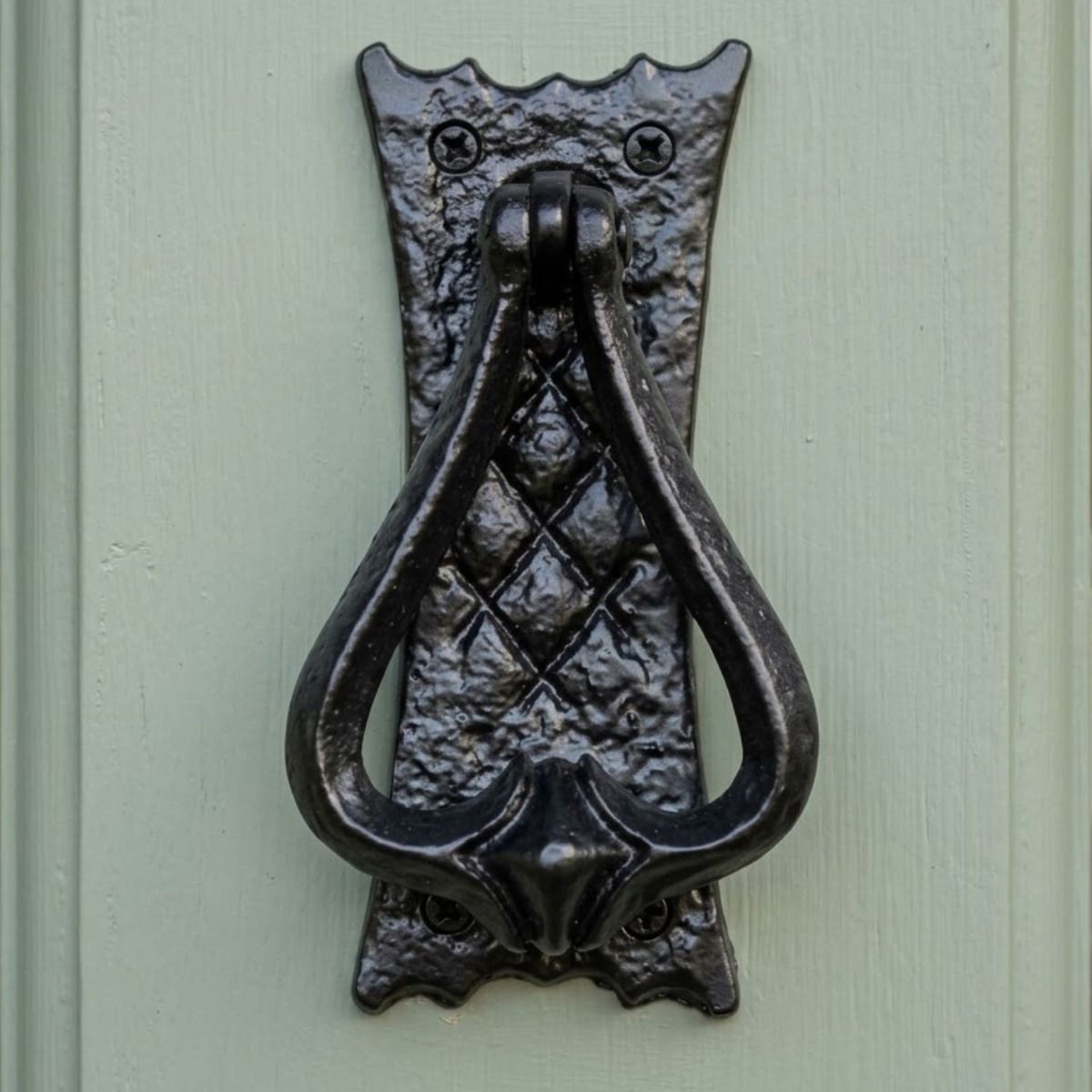 The "Alfarr" Bedroom Door Knocker Shown From the Front Mounted on a Light Green Door - Digital Illustration