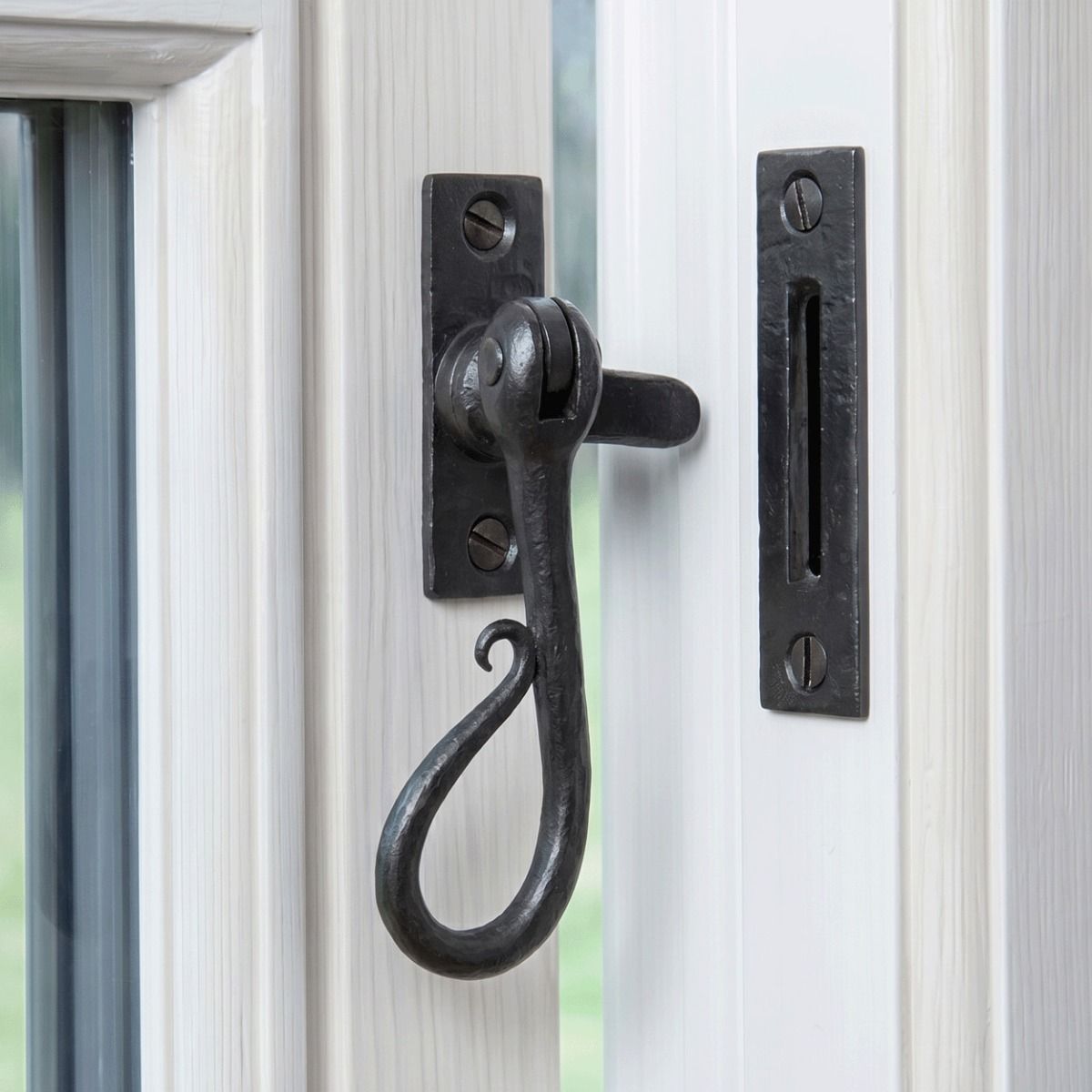 The "Appley Keep" Shepherd"s Crook Reversible Window Fastener in a Beeswax Finish Fitted on a White Window Frame in a Country Home - Digital Illustration 