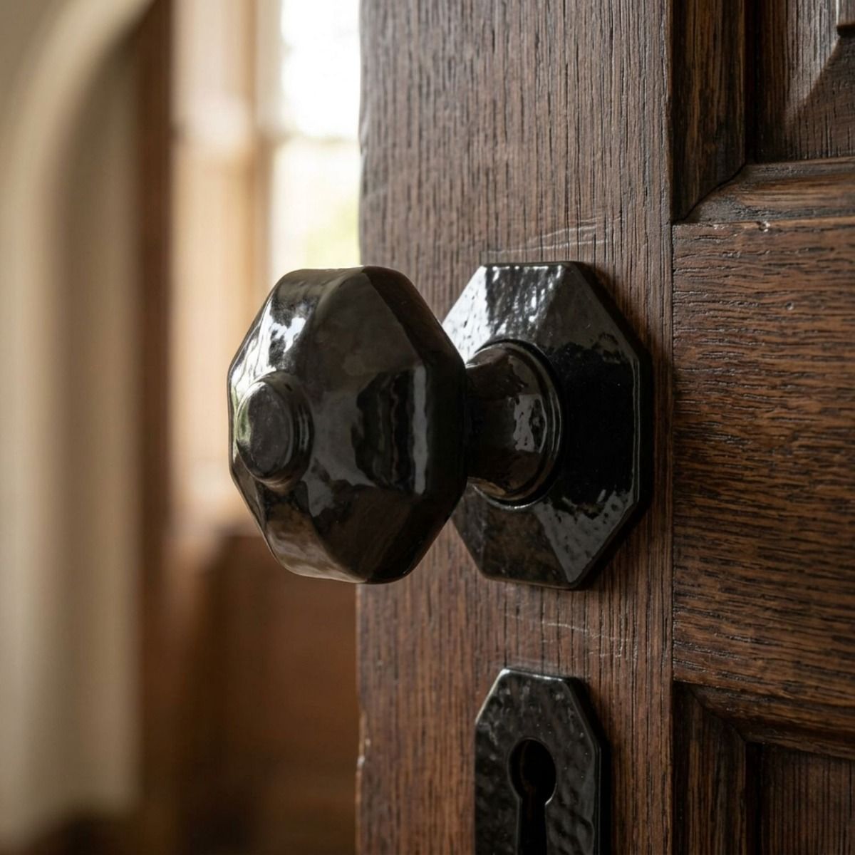 The "Audley" Black Octagonal Mortice or Rim Knob Set on a Dark Stained Wooden Door - Digital Illustration