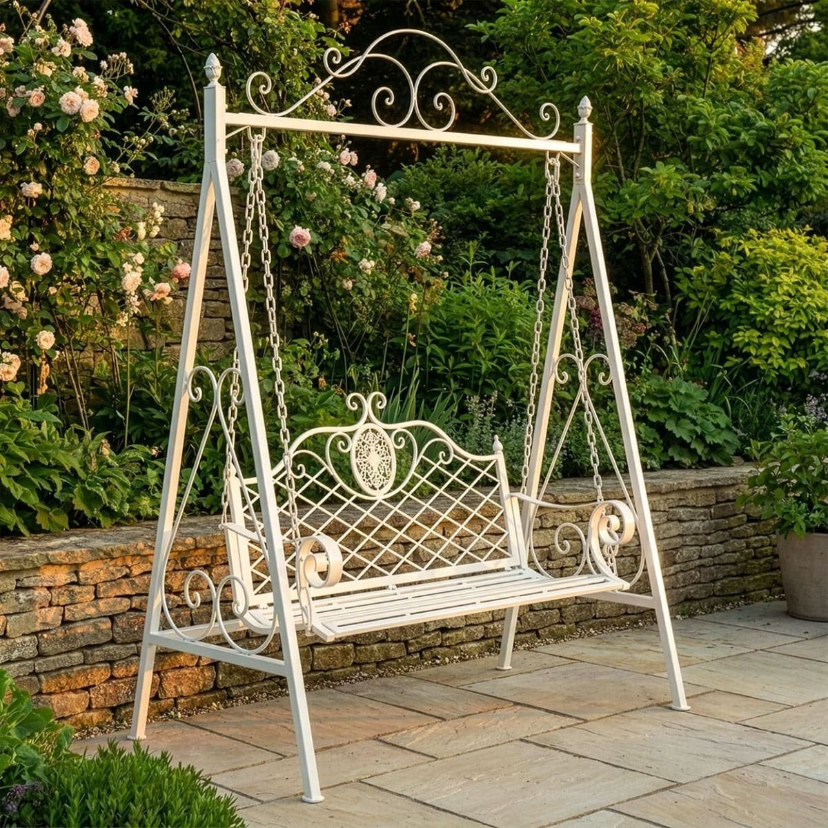 The "Blenheim" Ornate Arched Garden Swing Seat on a Sunny Garden Patio in a Cream Finish - Digital Illustration 