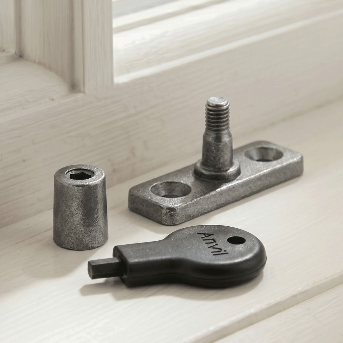 The "Bolsover" Pewter Locking Stay Pin Placed in Front of a Wooden White Window Frame in a Modern Home - Digital Illustration 