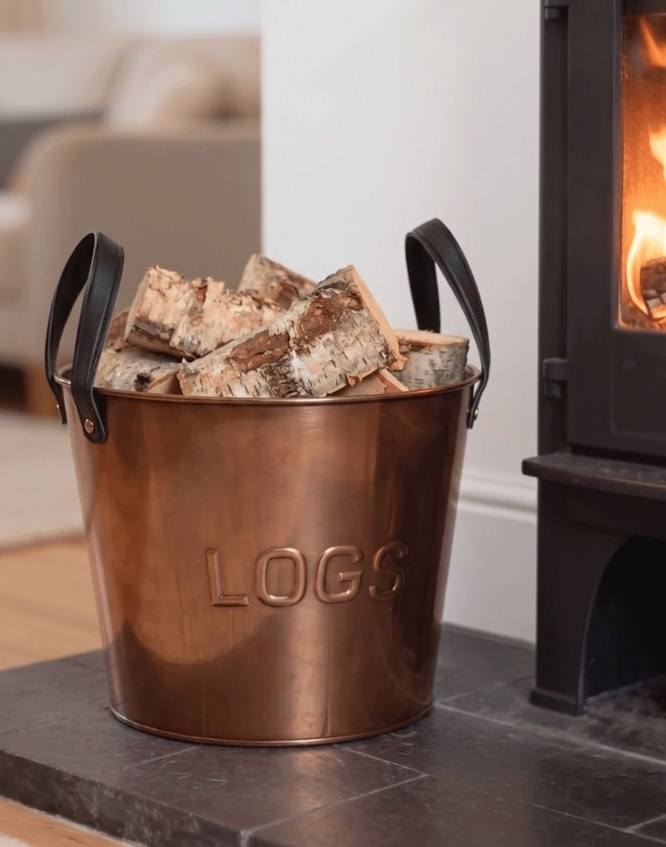 The "Bowerton" Bronze Powder Coated Steel Log Holder on a Stone Hearth next to a Log Burner - Digital Illustration