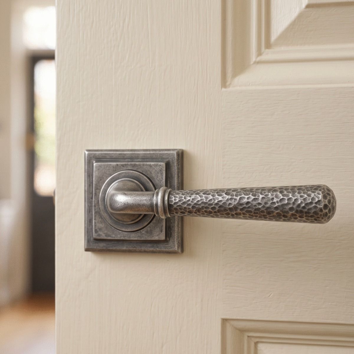 The "Clarissa" Pewter Hammered Lever Door Handle on Square Rose Shown Mounted on a Cream Coloured Door - Digital Illustration
