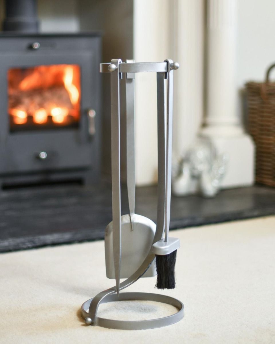 The "Contemporary Curved" Pewter Three Piece Companion Set in Front of a Modern Fireplace  - Digital Illustration