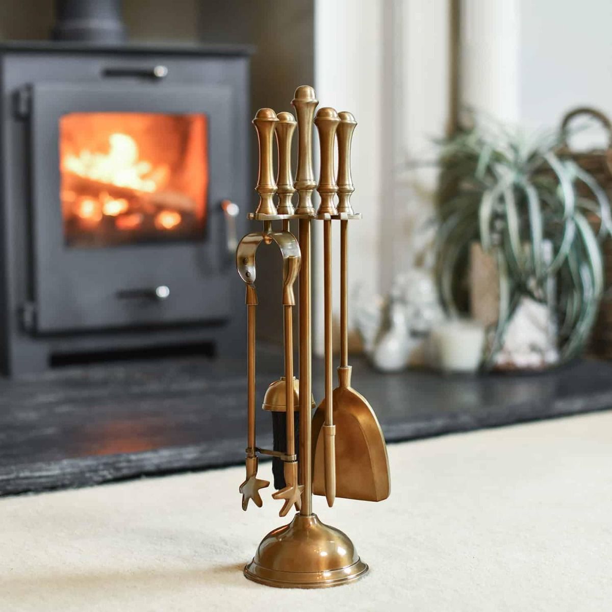 The "Coven Hall" Antique Brass Companion Set in a Modern Interior Setting next to a Log Burner Stove - Digital Illustration