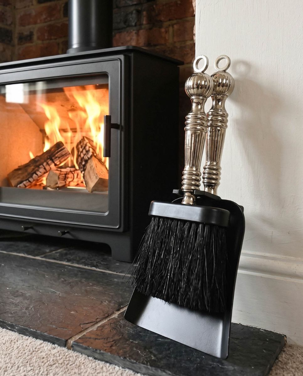 The "Farnhamford" Nickel and Black Iron Pan and Brush Set next to a Traditional Cottage Fireplace - Digital Illustration