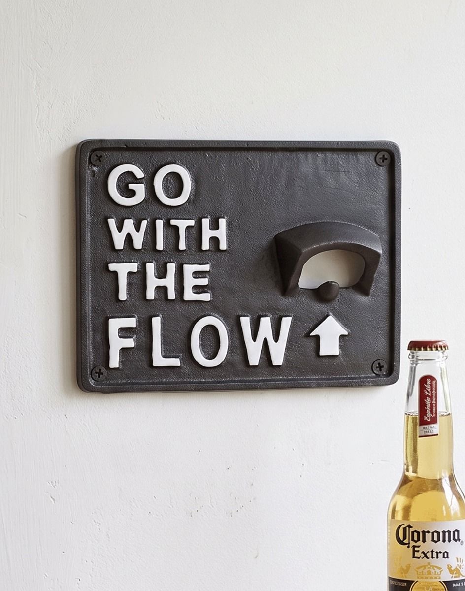 The "Go With The Flow" Iron Wall Mounted Bottle Opener Fixed to a White Painted Wall next to a Beer - Digital Illustration