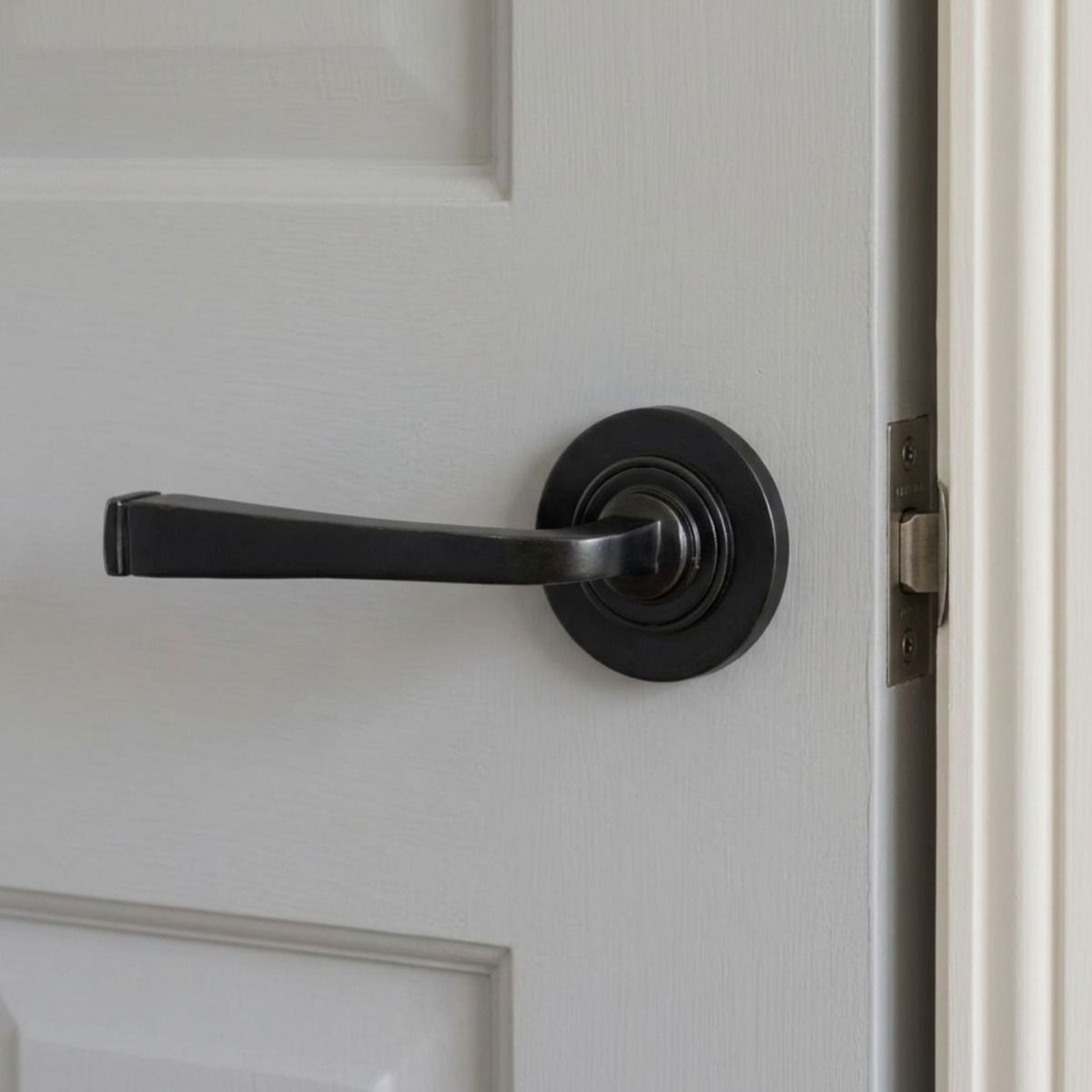 The "Grayson Manor" Midnight Black Unsprung Lever Door Handle on a Plain Rose Mounted onto a Light Grey Door - Digital Illustration 