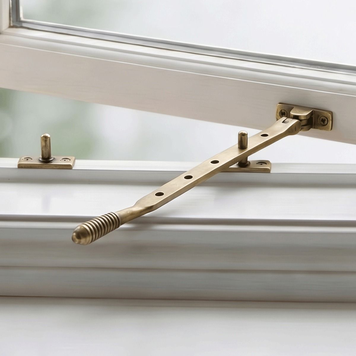 The "Harley Castle" Aged Brass Reeded Window Stay Fitted on a Traditional Wooden Window - Digital Illustration