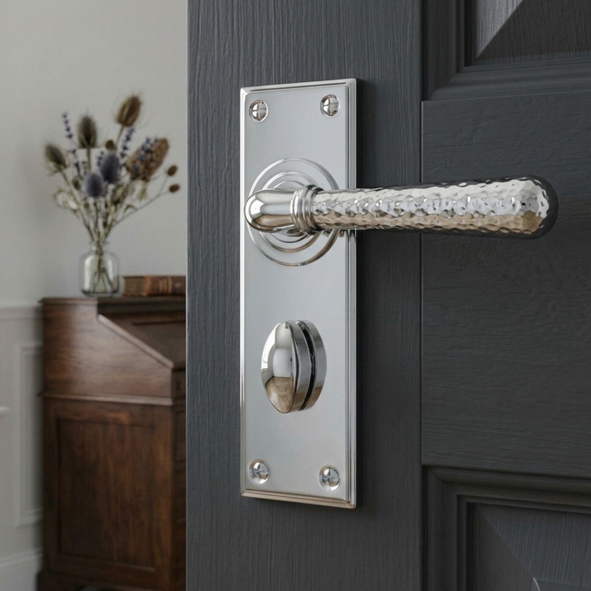 The "Harriot House" Hammered Bright Chrome Lever Bathroom Door Handle on a Charcoal Grey Door in a Modern Home Interior - Digital Illustration 