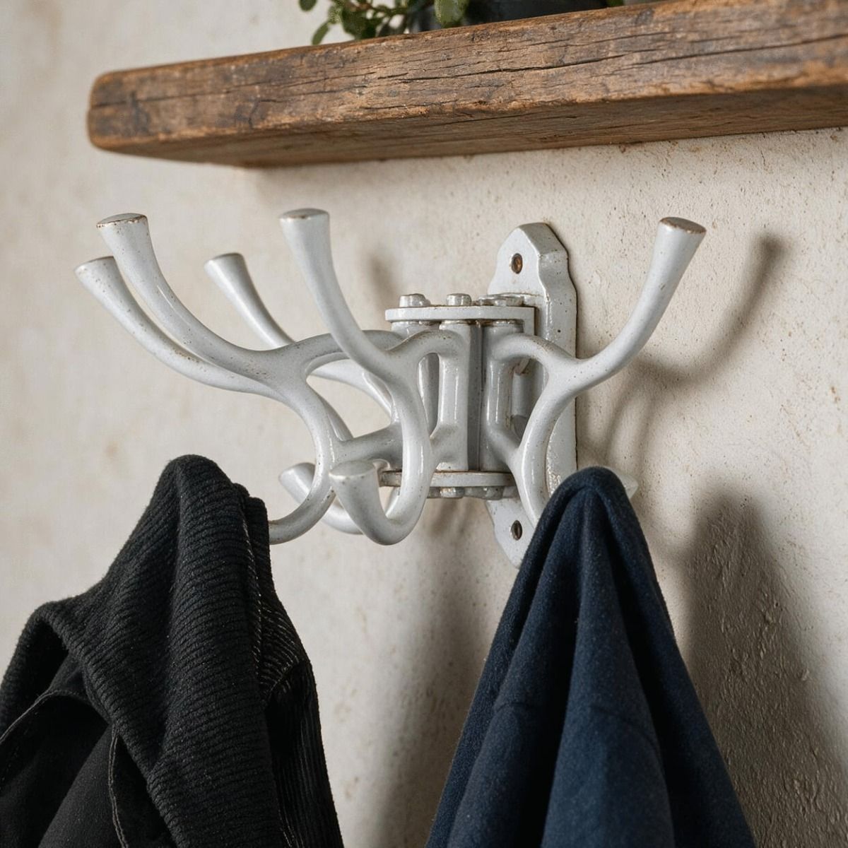 The "Kynaston Avenue" Swivel Hook in White Displayed Attached to a White Wall with two Jackets Hung on it - Digital Illustration 