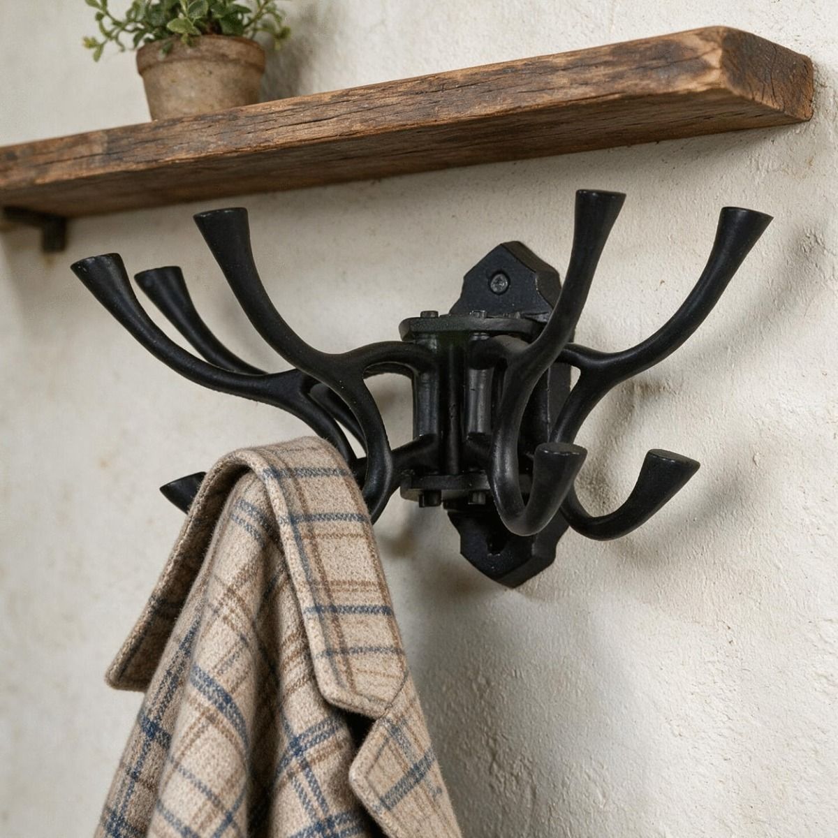 The "Kynaston Avenue" Swivel Hook Rack in Black Shown Close up on a White Wall Beneath a Timber Shelf - Digital Illustration