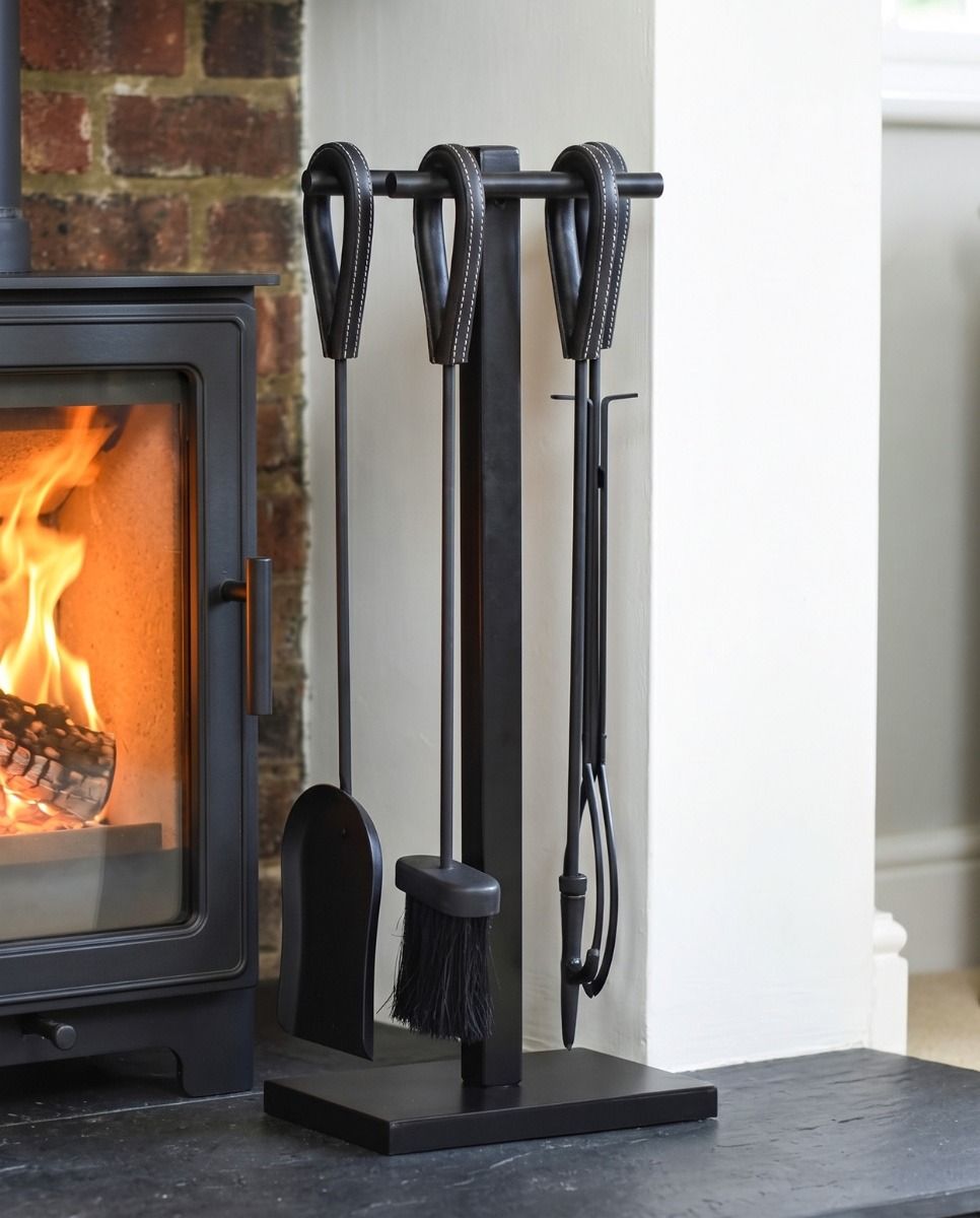 The "Lateral Loop" Black Companion Set with Leather Handles in a Modern Interior Setting next to a Log Burner Stove - Digital Illustration