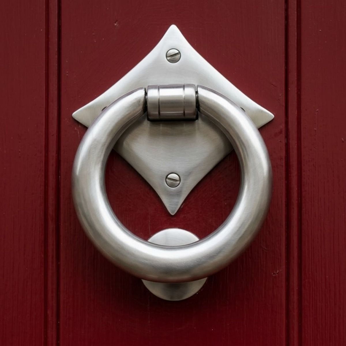 The "Lorien" Ring Door Knocker in Satin Stainless Steel Shown Front on Mounted to a Red Door - Digital Illustration