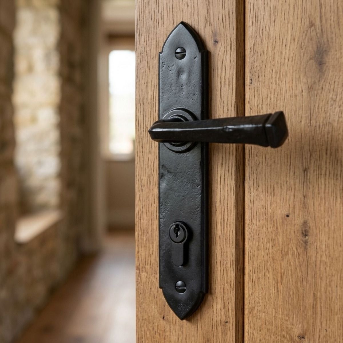 The "Orelia" Black Gothic Lever Espagnolette Lock Set on a Wooden Door in a Sun Lit Entrance Hall - Digital Illustration