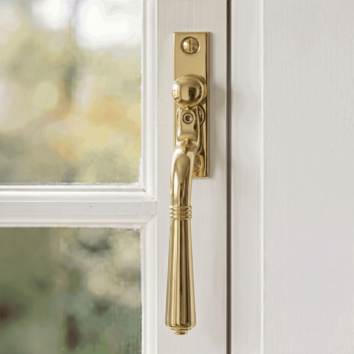 The "Regency" Polished Brass Teardrop Espagnolette Window Fastener Mounted on a Wooden Painted Window Frame - Digital Illustration 