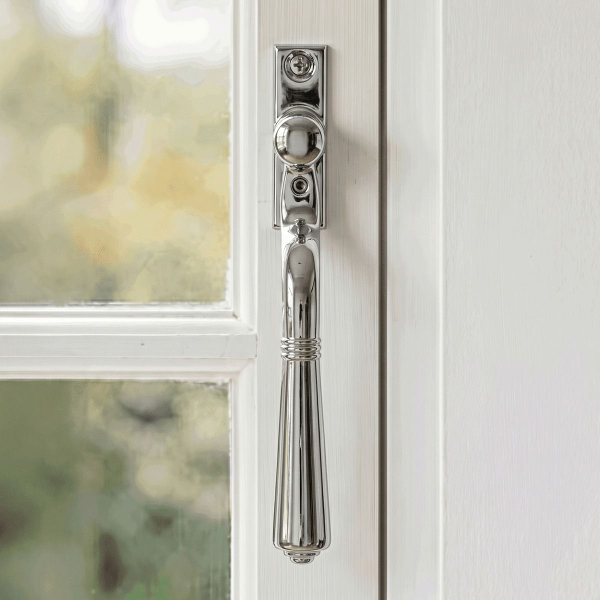 The "Regency" Polished Chrome Teardrop Espagnolette Window Fastener Fitted on a White Painted Window Frame - Digital Illustration