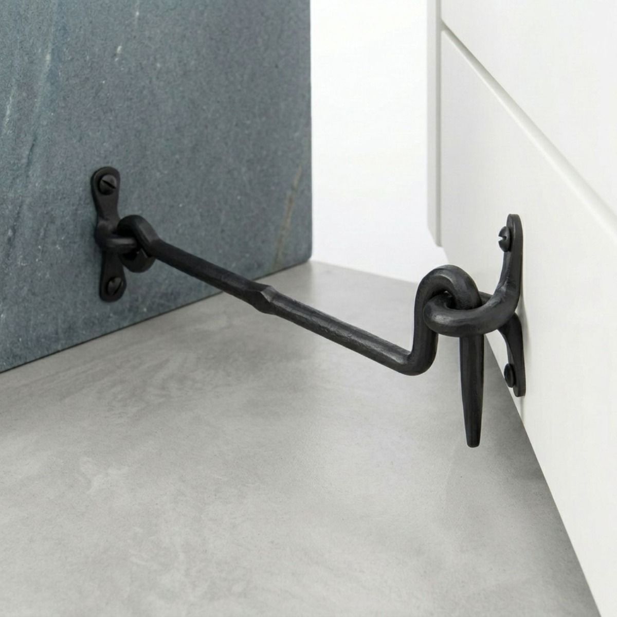 The "Siena" Black Forged Cabin Hook 12" on a White Cabinet Door - Digital Illustration 