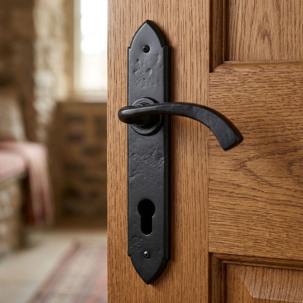 The "Verona" Black Gothic Curved Espagnolette Lock Set mounted on the Door of a Rustic Cottage Living Room - Digital Illustration