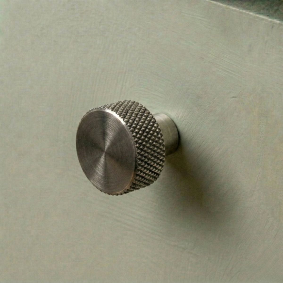 The "Vesper" Knurled Edge Cabinet Knob in Pewter for Kitchen Cupboards Mounted on a Sage Green Drawer - Digital Illustration 