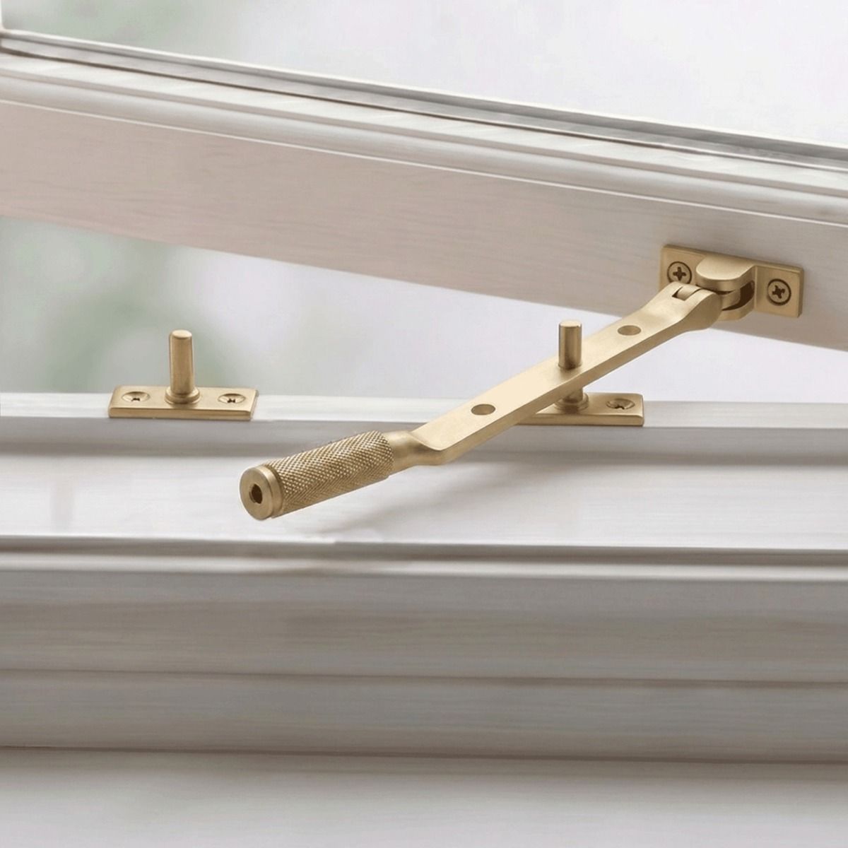 The 248mm 8" Satin Brass "Royale" Three Pin Window Stay Fitted on a Classic White Wooden Window Frame - Digital Illustration