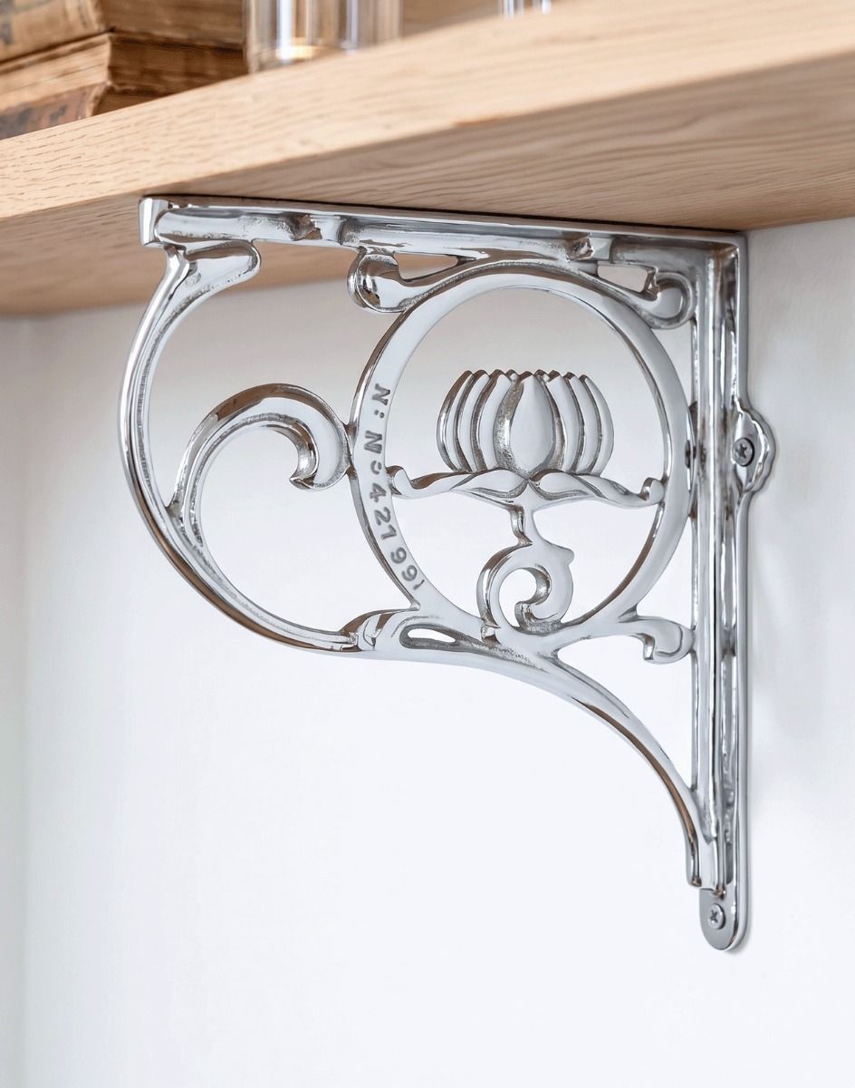 The 25 x 23cm "Lotus Flower" Bright Chrome Wall Bracket Mounted on a White Modern Interior Wall - Digital Illustration