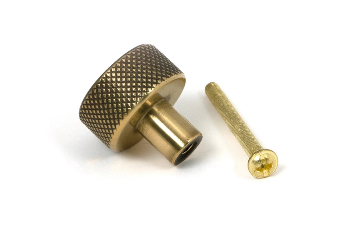 The 25mm "Vesper" Knurled Edge Cabinet Knob in Aged Brass on a White Background Shown from Behind with the Screw