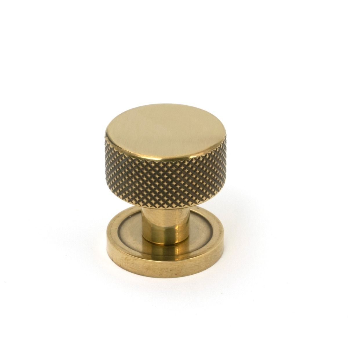 The 25mm Knurled Cabinet Knob on a Plain Rose in Aged Brass Shown Upright on a White Background 