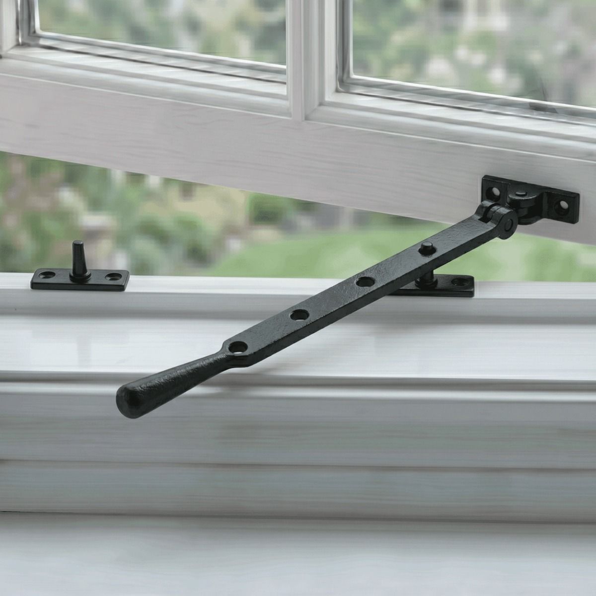 The 296mm 10" Black Four Pin Window Stay in a Black Finish Fitted on a Classic White Open Window - Digital Illustration