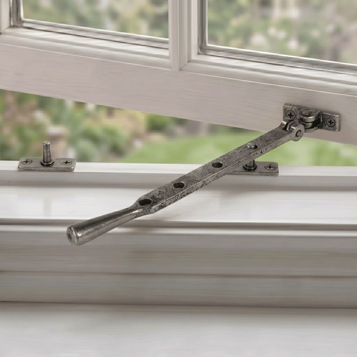 The 296mm 10" Pewter Four Pin Window Stay Fitted on a White Open Window Frame - Digital Illustration