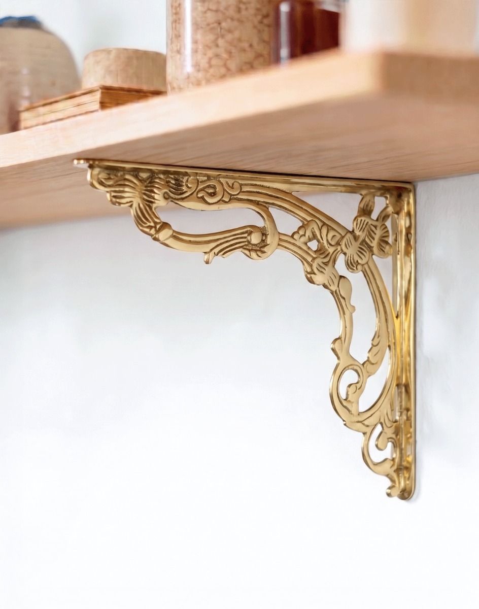 The 30 x 25cm Ornate “Victorian Amalina” Scroll Bracket in Polished Brass Mounted on a Bright white Coloured Modern Interior Wall on a DIY Shelf - Digital Illustration