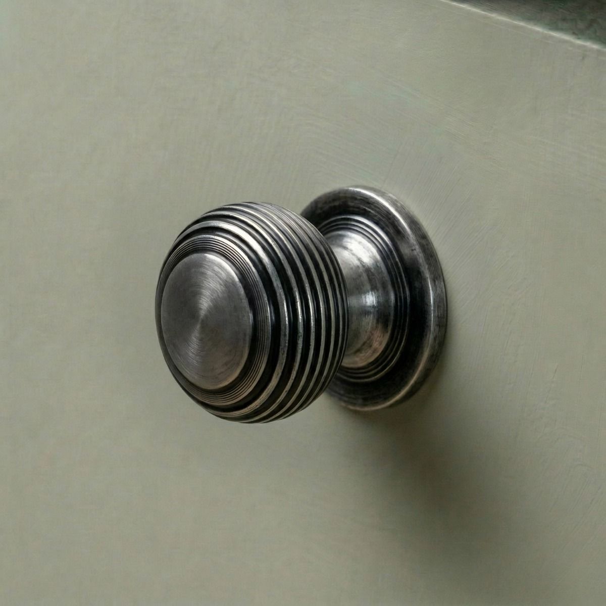 The 30mm "Garrison" Ribbed Beehive Knob in a Pewter Finish Fitted on to a Sage Green Kitchen Cupboard - Digital Illustration