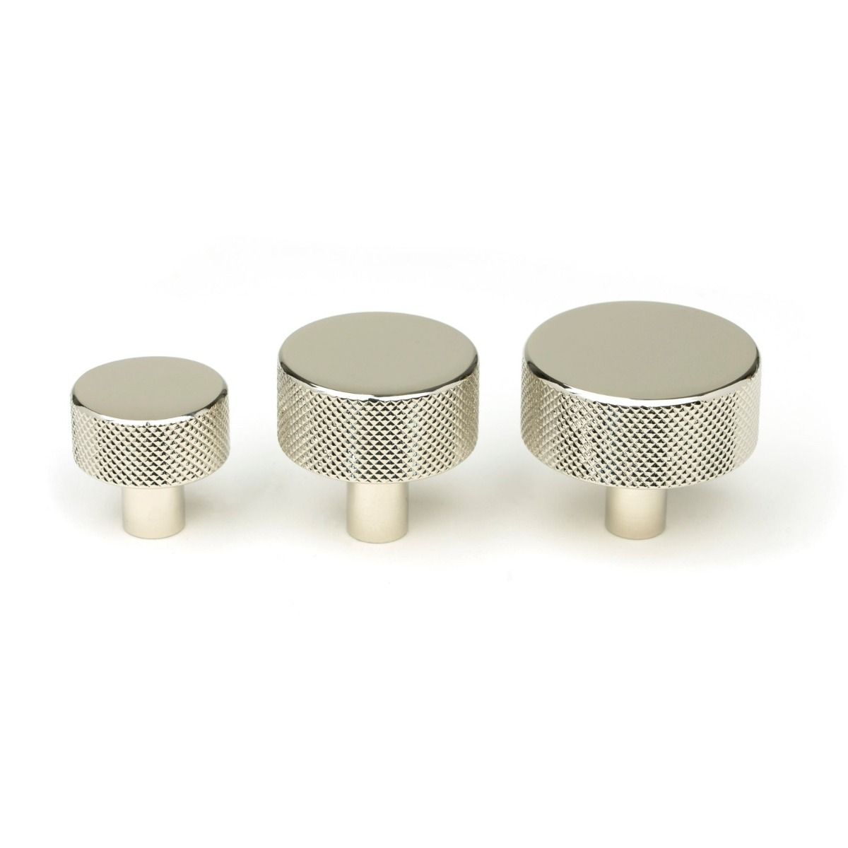 The 32mm Knurled Cabinet Knob (No Rose) in Polished Nickel Alongside Different Sizes on a White Background