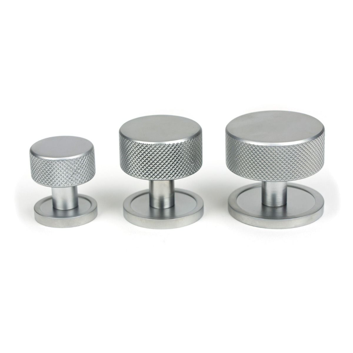 The 32mm Knurled Cabinet Knob on a Plain Rose in Satin Chrome Alongside Different Sizes