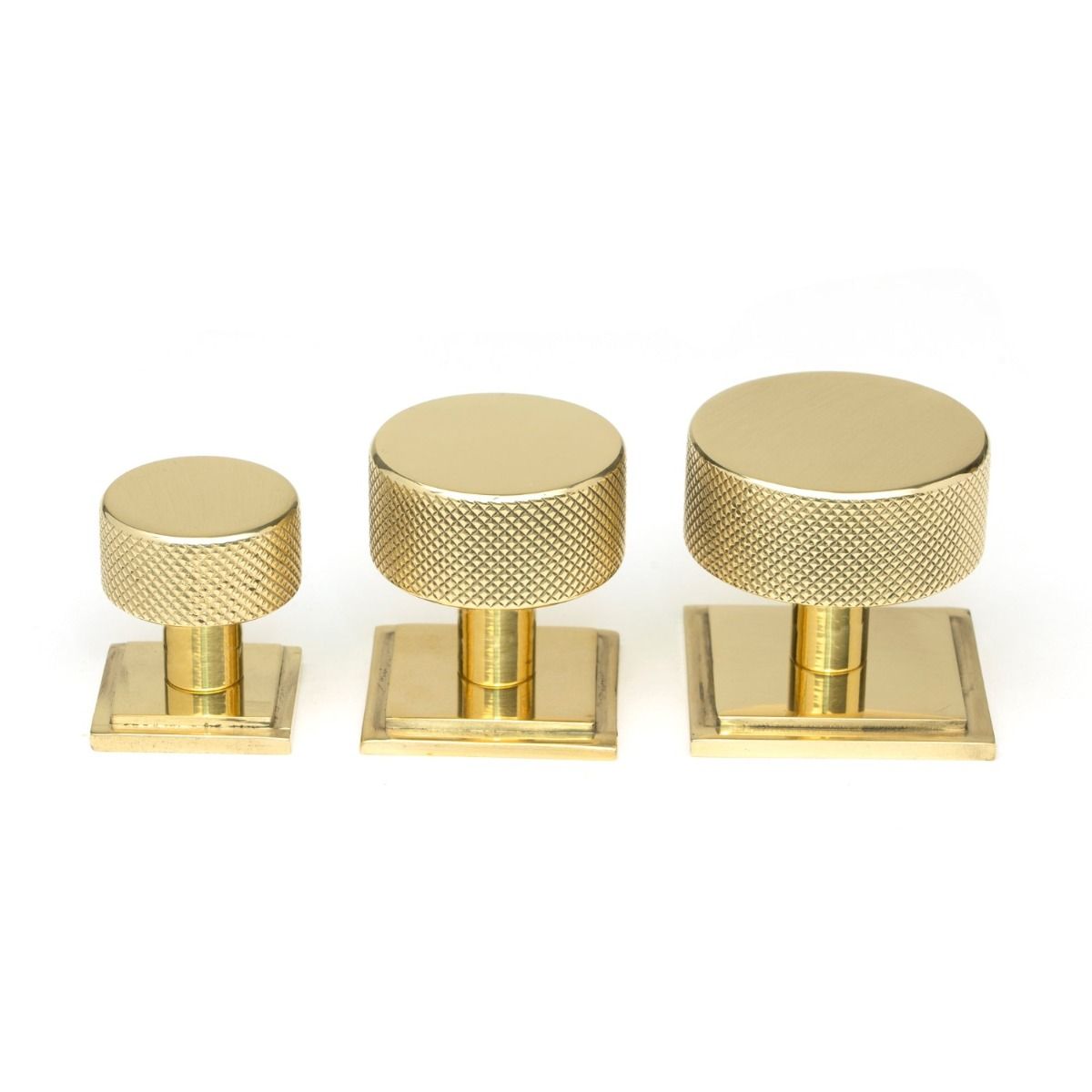 The 32mm Knurled Cabinet Knob on a Square Rose in Polished Brass Alongside Different Sizes