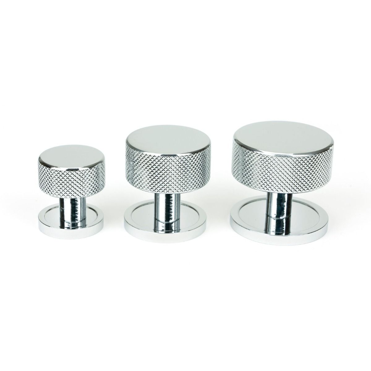 The 32mm Knurled Cabinet Knob on Plain Rose in Polished Chrome Alongside Different Sizes on a White Background