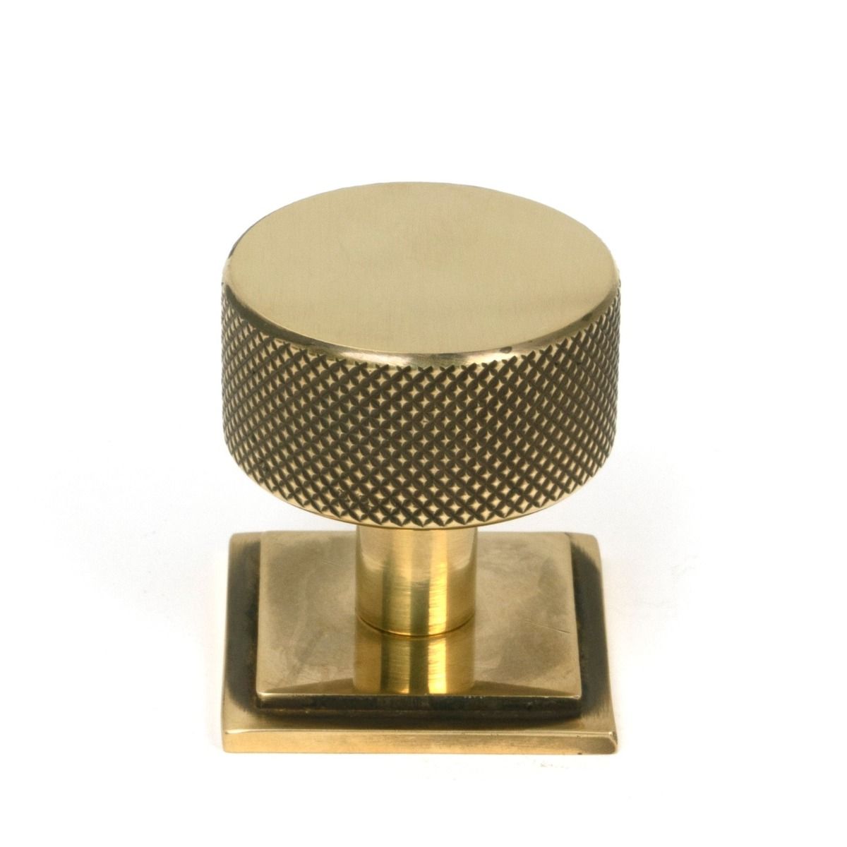 The 32mm Knurled Cabinet Knob on Square Rose in Aged Brass Shown Upright on a White Background