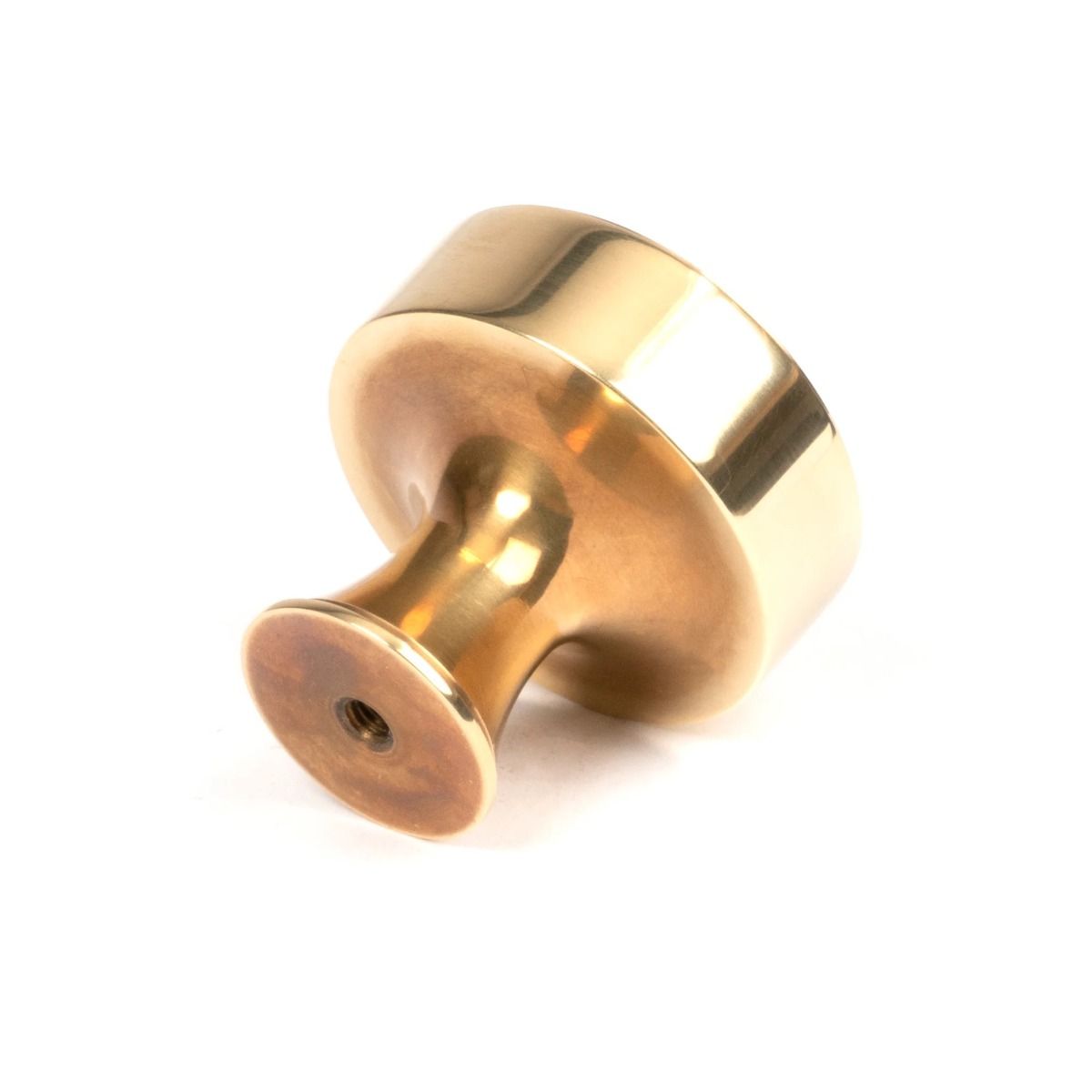 The 38mm "Atelier" Circular Cabinet Knob in Aged Brass on a White Background Shown from Behind
