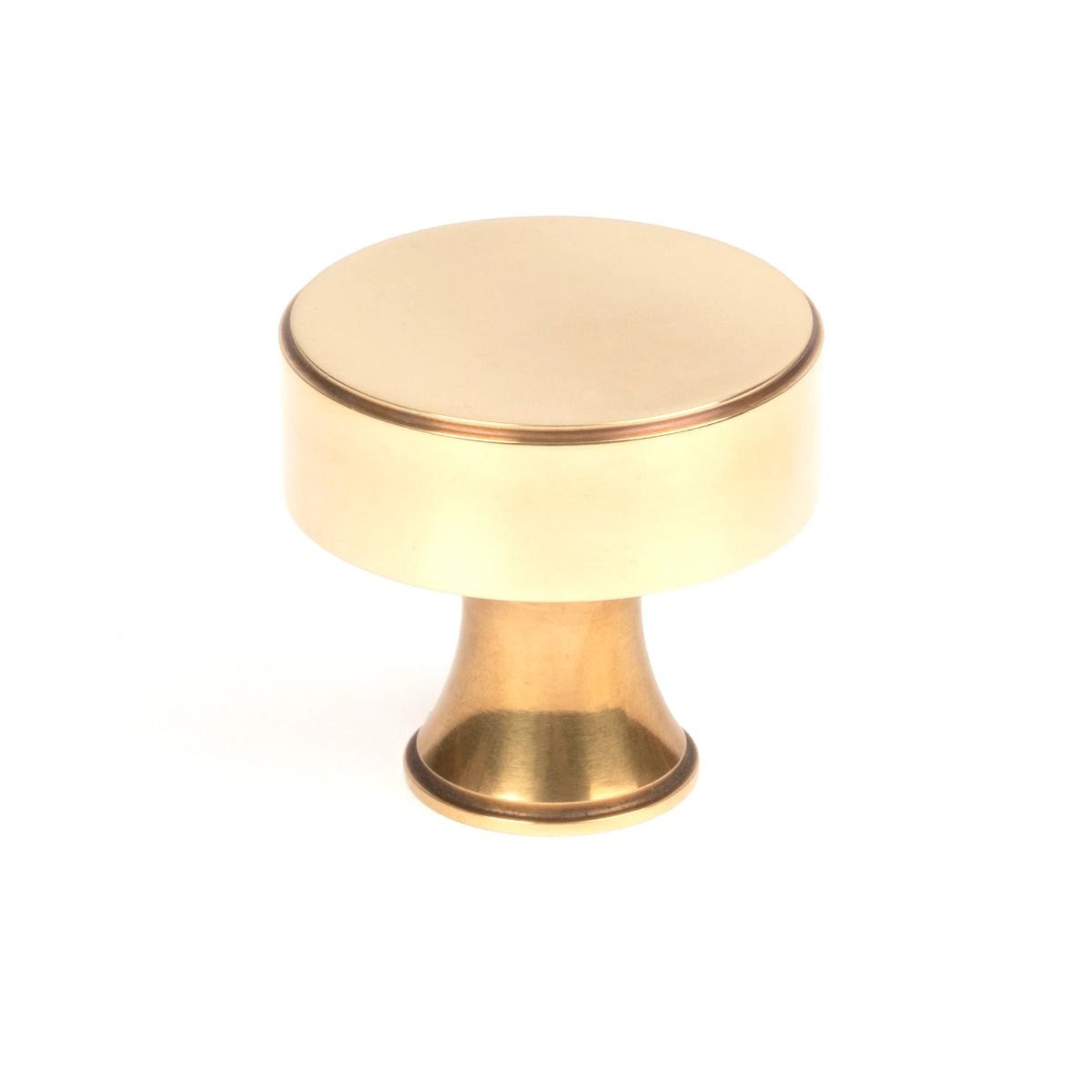 The 38mm "Atelier" Circular Cabinet Knob in Aged Brass on a White Background Shown Upright