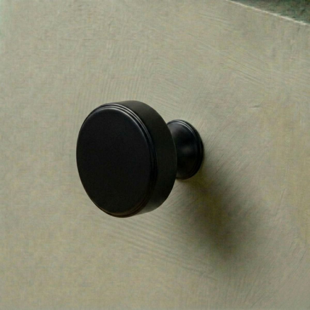 The 38mm "Atelier" Circular Cabinet Knob in Matt Black Designed for Kitchen Cupboards Mounted on a Green Drawer - Digital Illustration 