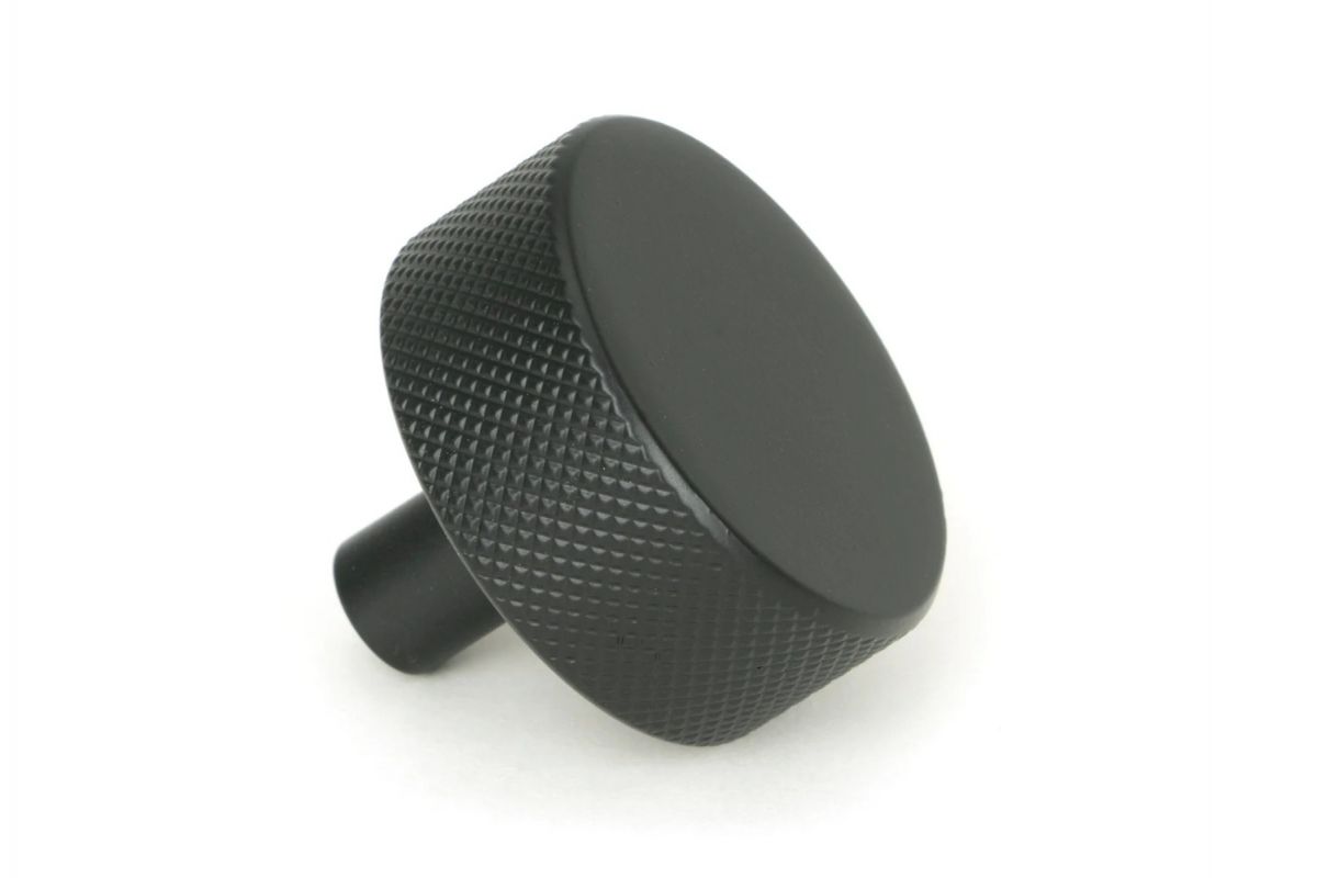 The 38mm "Vesper" Knurled Edge Cabinet Knob in Matt Black on a White Background Shown from the Side