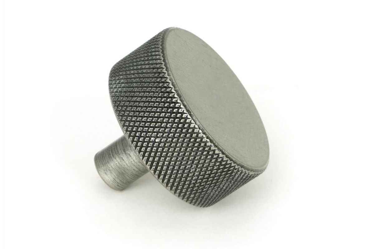 The 38mm "Vesper" Knurled Edge Cabinet Knob in Pewter Mounted on a White Background Shown frm the Side