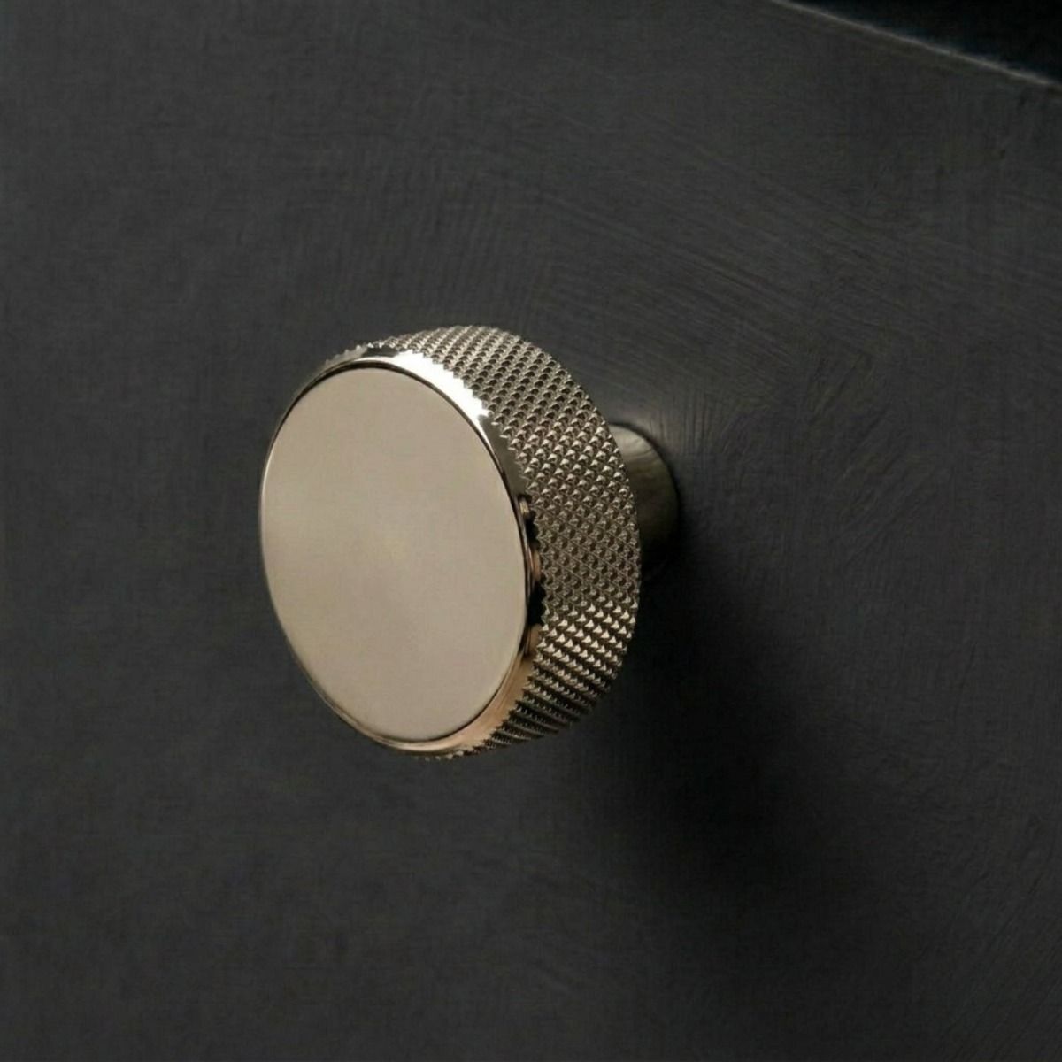 The 38mm "Vesper" Knurled Edge Cabinet Knob in Polished Nickel Designed for Kitchen Cupboards Displayed on a Contemporary Wooden Drawer - Digital Illustration