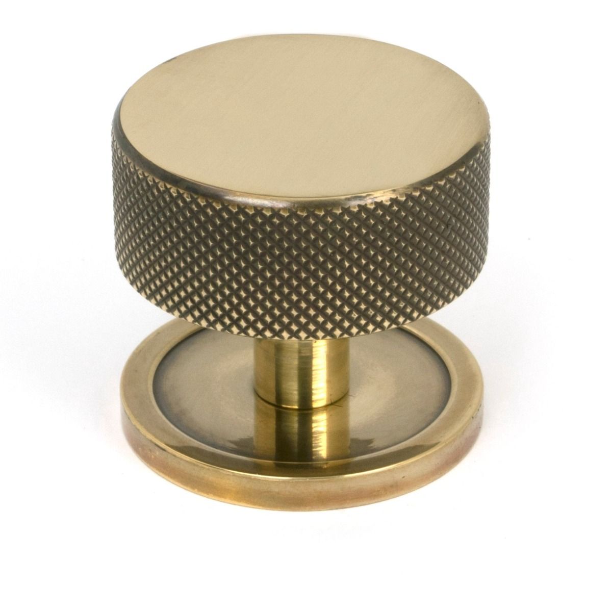 The 38mm Knurled Cabinet Knob on a Plain Rose in Aged Brass Shown Upright on a White Background