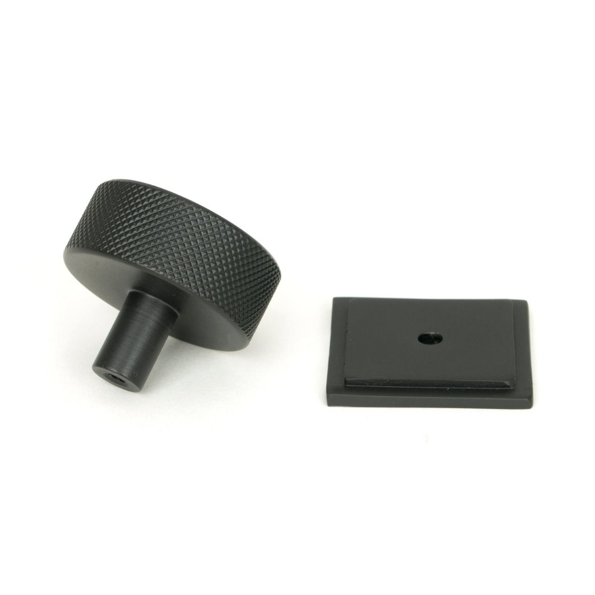 The 38mm Knurled Cabinet Knob on a Square Rose in Matt Black Shown from Behind on a White Background