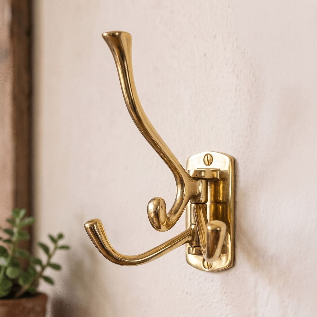 A Close up of the 3 Prong Brass "Swivel" Hook Mounted on a Cream Wall - Digital Illustration 